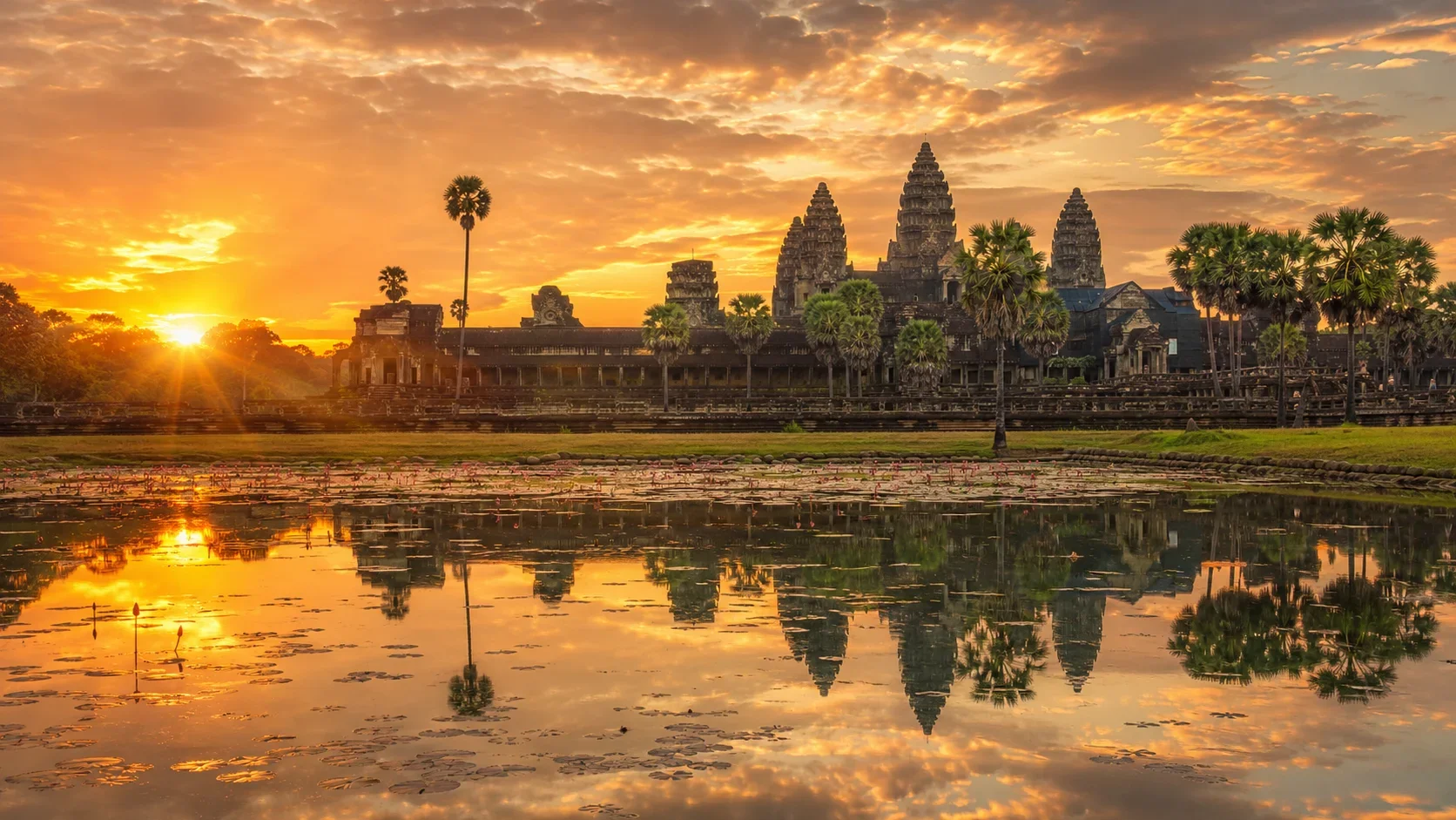 Angkor Wat reflected in the water at sunrise during Cambodia's dry season